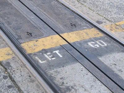 sidewalk depicting the words let go painted on the ground